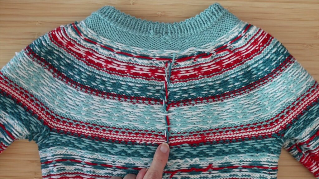 Envers de l'empiècement jacquard de Little Christmas, un fil de couleur remonte verticalement au milieu du dos sans avoir été coupé